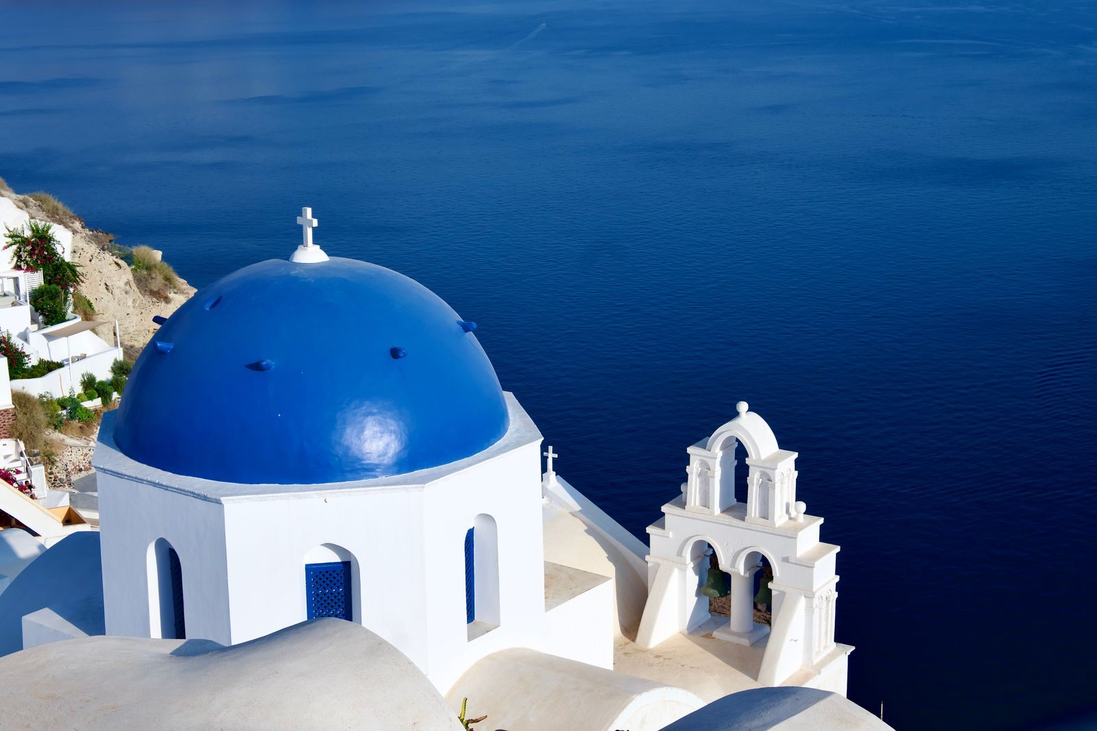 Blue-domed church above the deep blue Aegean Sea in Santorini