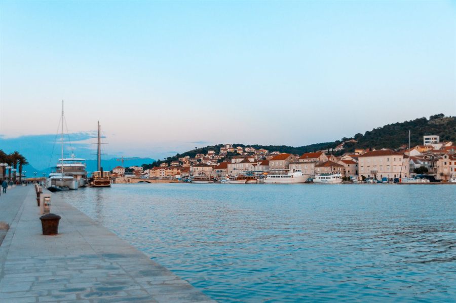 Harbor promenade and sailboats in a Croatian coastal town at dusk