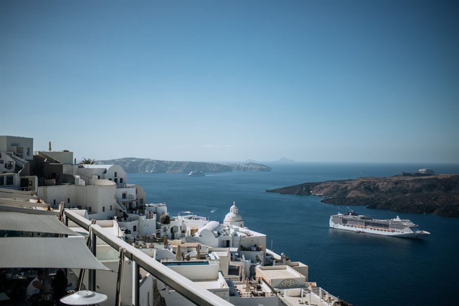 Cruise ship anchored off a whitewashed Greek island town