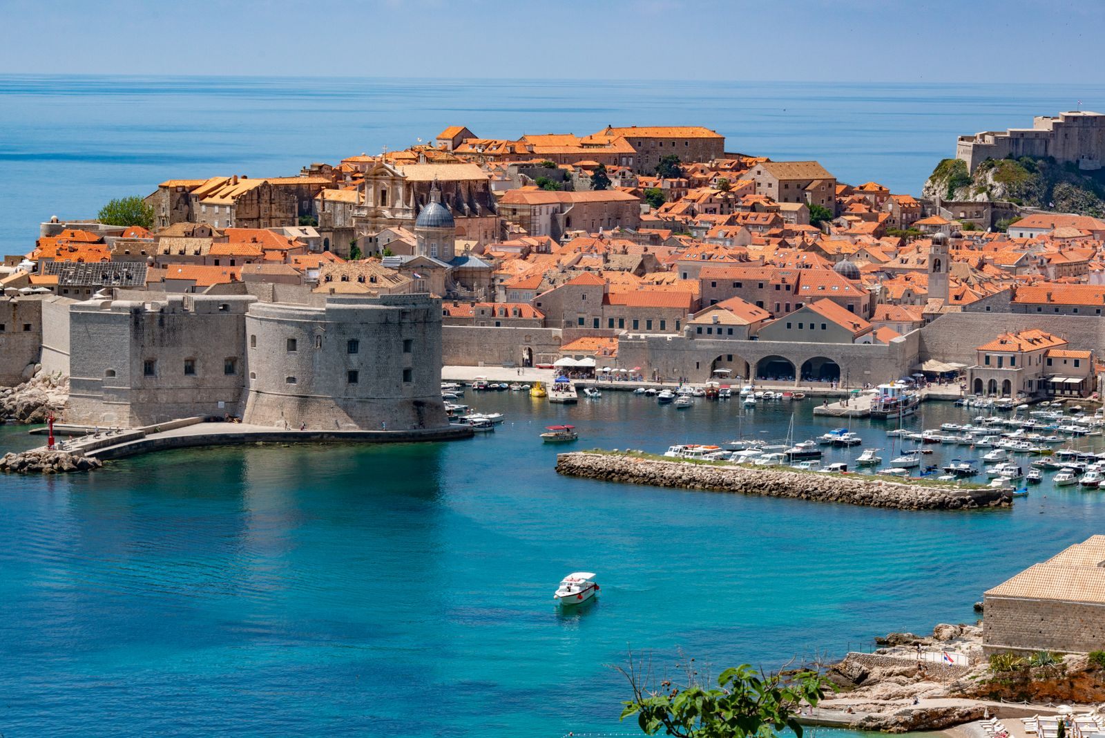 Dubrovnik old town walls and harbor above blue water, a port on the best Mediterranean cruises